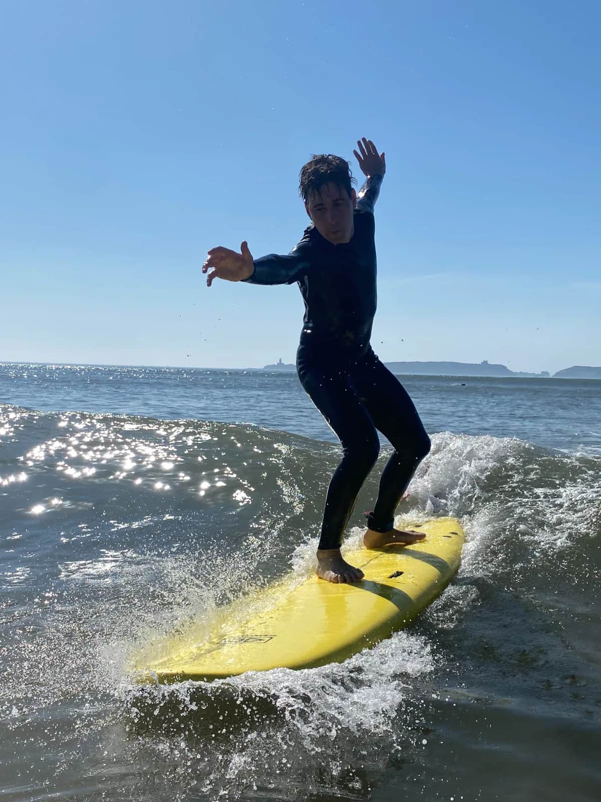 Surfer riding a yellow board on an Essaouira wave